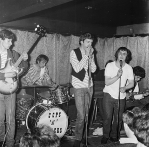 Cops n Robbers original six piece, left to right: Steve Smith, Henri Harrison, Keith Canadine, Terry Fox (hidden behind singer Smudger), Smudger Smith, Brian Raines. Photo: Studio Club 1964, by kind permission of John Ricks.